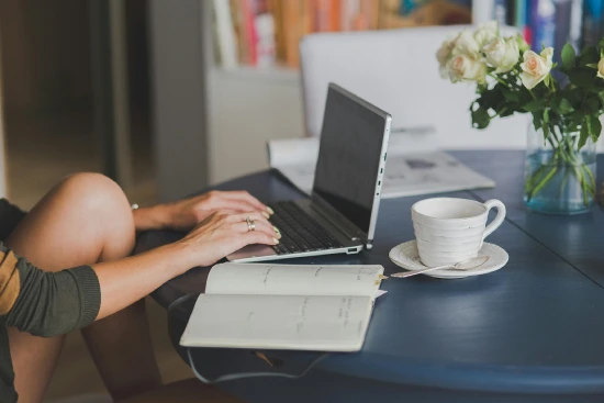 a woman reading and working from home, in front of her macbook
